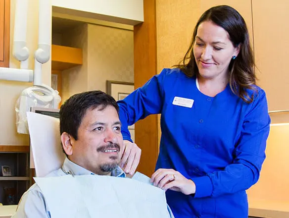 dental hygenist prepping patient for dental exam