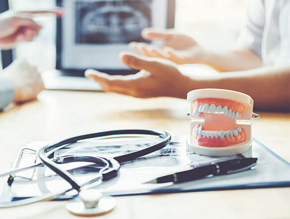 dental-insurance stethoscope and model of teeth on desk